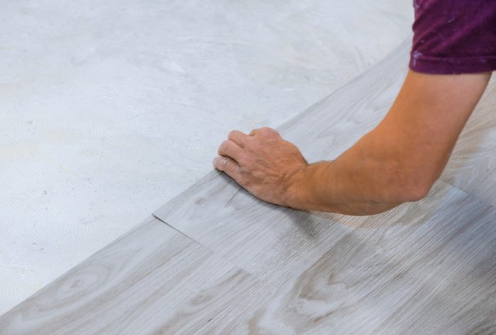Work on laying worker installing new vinyl tile laminate floor.