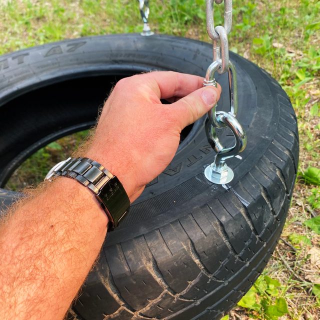 connecting the chains to the eye hooks in a tire for a tire swing