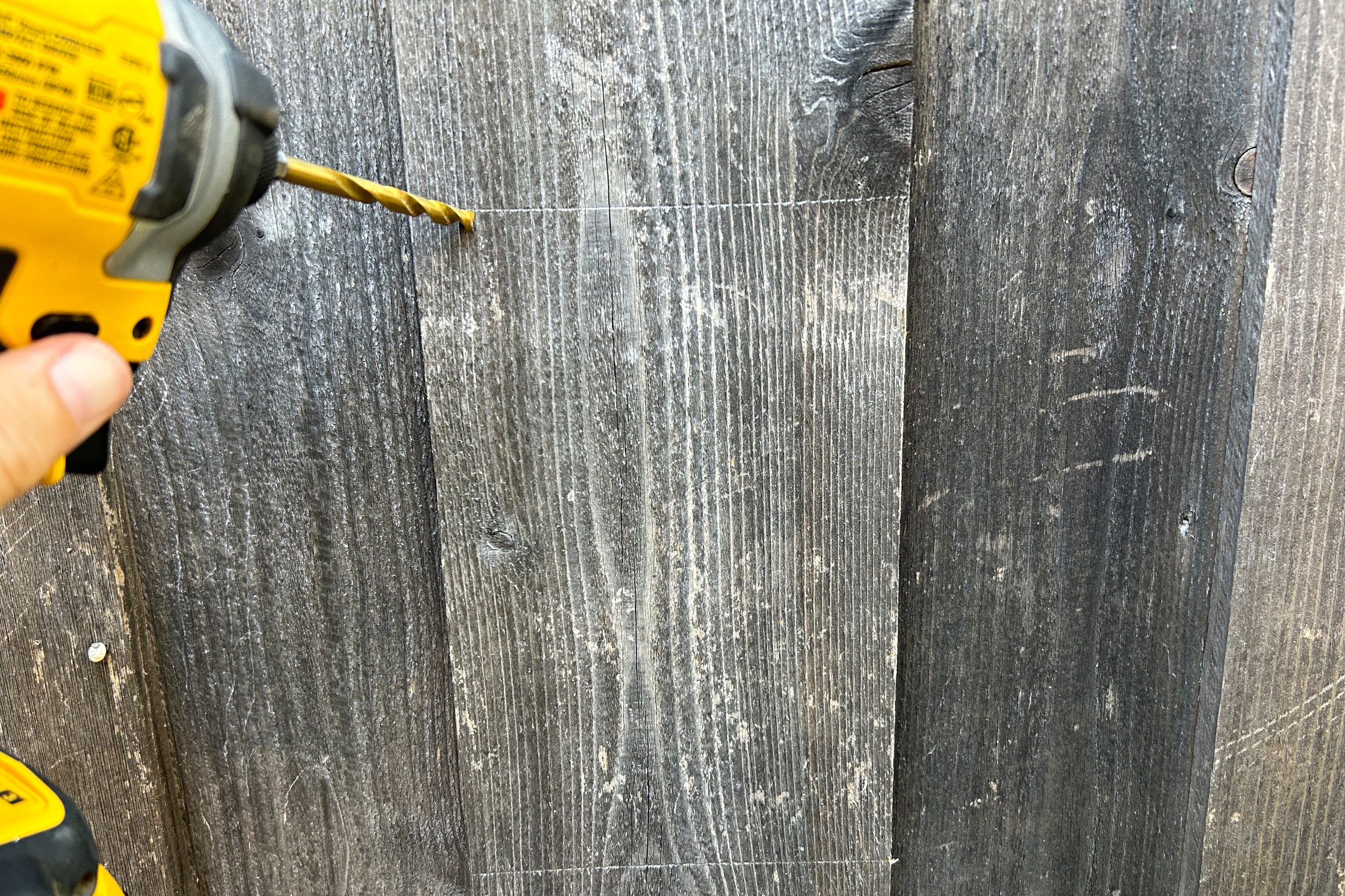 drilling a hole in the fence