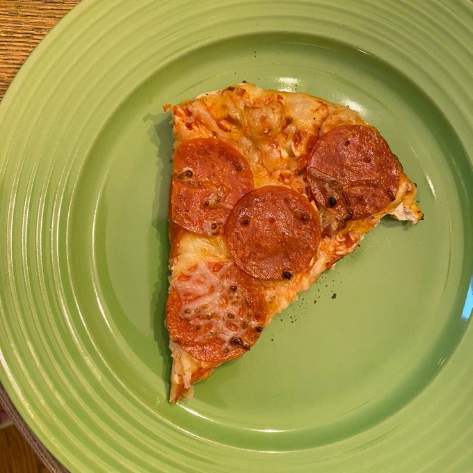 pizza slice on a green plate made with the Solo Stove Pi Fire