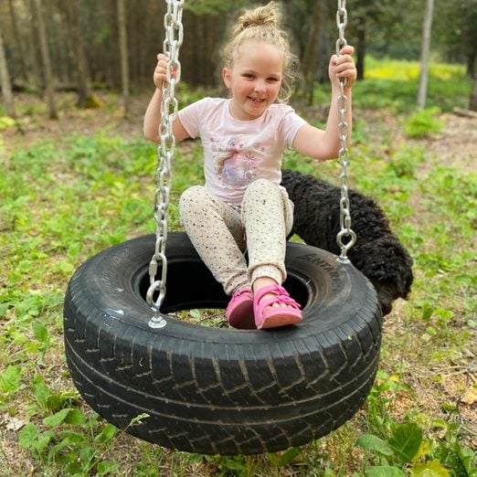 young girl on a tire swing