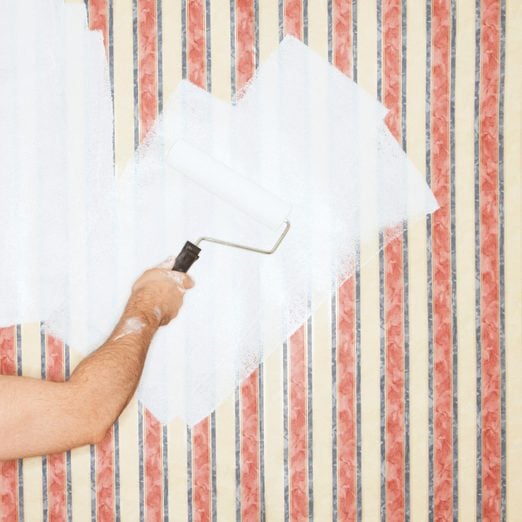 painting over stripped wallpaper with white paint on a roller