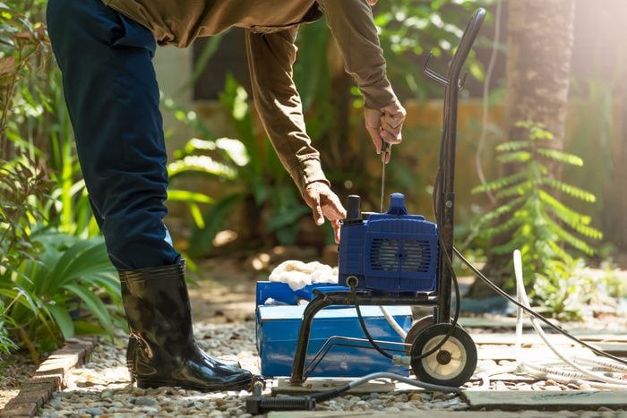 person doing repairs on a gas powered pressure washer