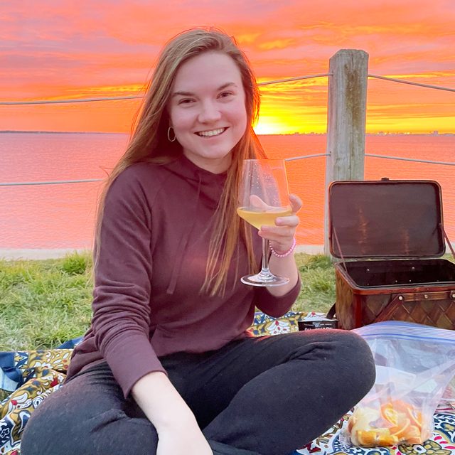 woman wearing a Bamboo Fleece Jogger while drinking wine at sunset