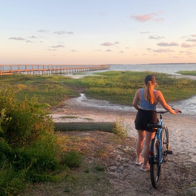 woman riding a bike into the sunset wearing Breeze Shorts Free Fly