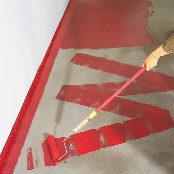 applying red epoxy to garage floor