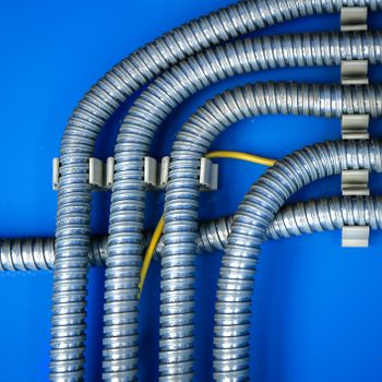 Wiring, distribution of wires in a metal corrugation on a blue background