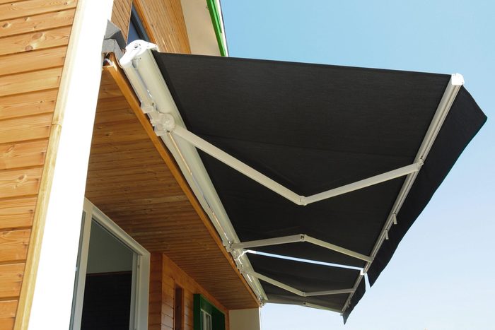 Outdoor high quality automatic sliding canopy retractable roof system, patio awning for sunshade of a modern wooden house.