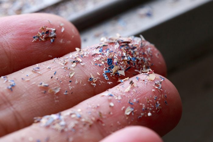 Close up of microplastics on a human hand for scale