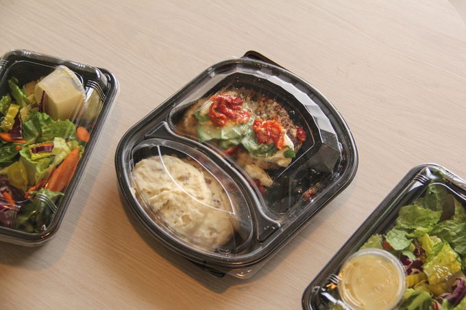 Plastic containers of prepared food at kitchen table