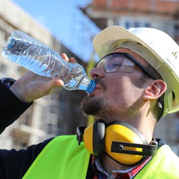 Boss At Construction Site With Bottle Of Water