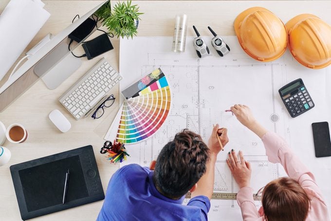 Architects working on blueprint of a new home construction build