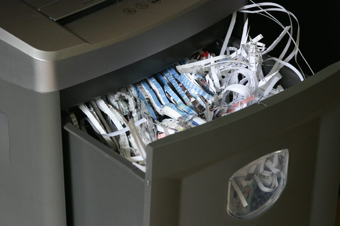 documents shredder close up with shredded paper in the bin