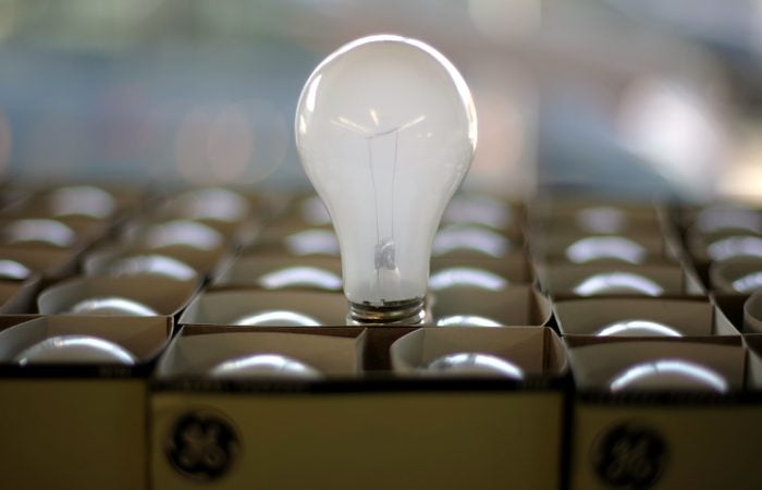 An Incandescent light bulb pops out of a box of lightbulbs in the City Lights Light Bulb Store in San Francisco, California