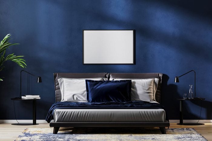 Dark Midnight Blue Bedroom Interior With Bed, Plant, Artwork, Nightside Tables and a rug