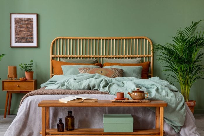 Sage Green Stylish Bedroom Interior Design With Mock Up Poster Frame, Bamboo Bed, Night Table, Plants, Folding Screen And Creative Home Accessories