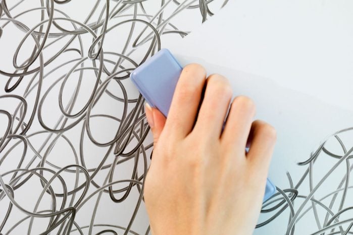 Hand Erasing Scribbled Lines on a Whiteboard with a hand eraser to remove expo marker