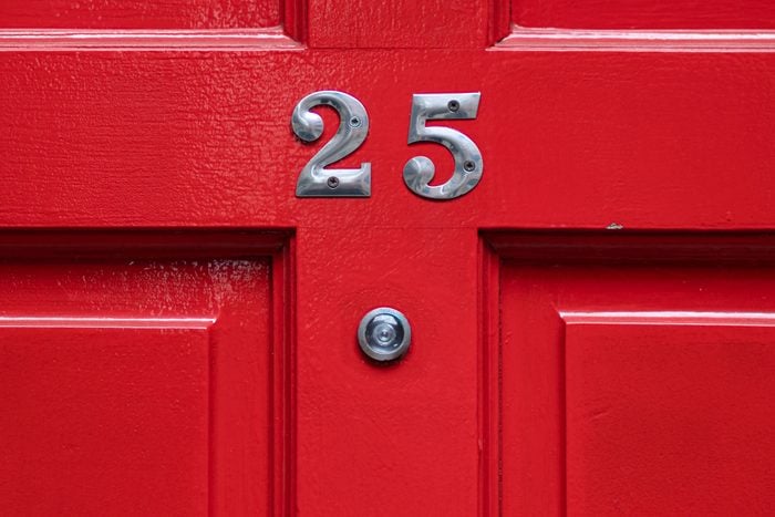 Detail Of A Red Door With Number 25 and peephole