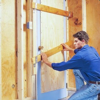 man adding Plywood Reinforcement to a Wooden Garage Entry Door