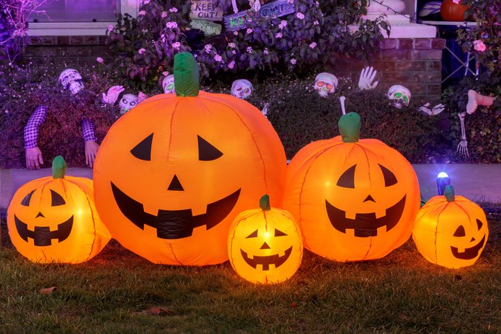 Inflatable pumpkin decorations glowing in the front yard of a house