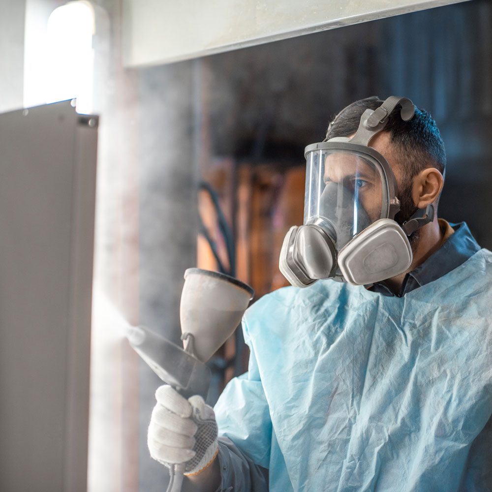 Painter in Protective Gear Paints Metal Products With Powder Coating Paint Gun