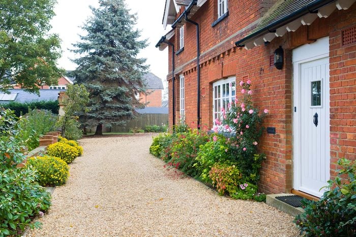 English Country House with Gravel & Bushes Covered Pathway