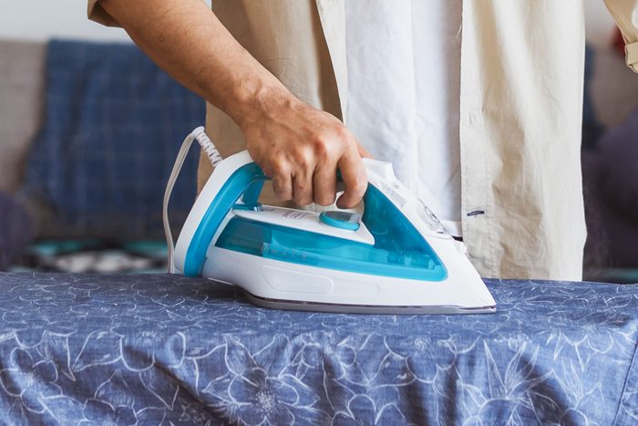 a man ironing a shirt