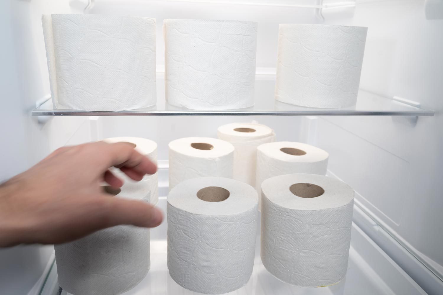 A Person Is Going To Take Or Leave A Roll Of Toilet Paper Inside A Refrigerator That Is Full Of Toilet Paper Rolls