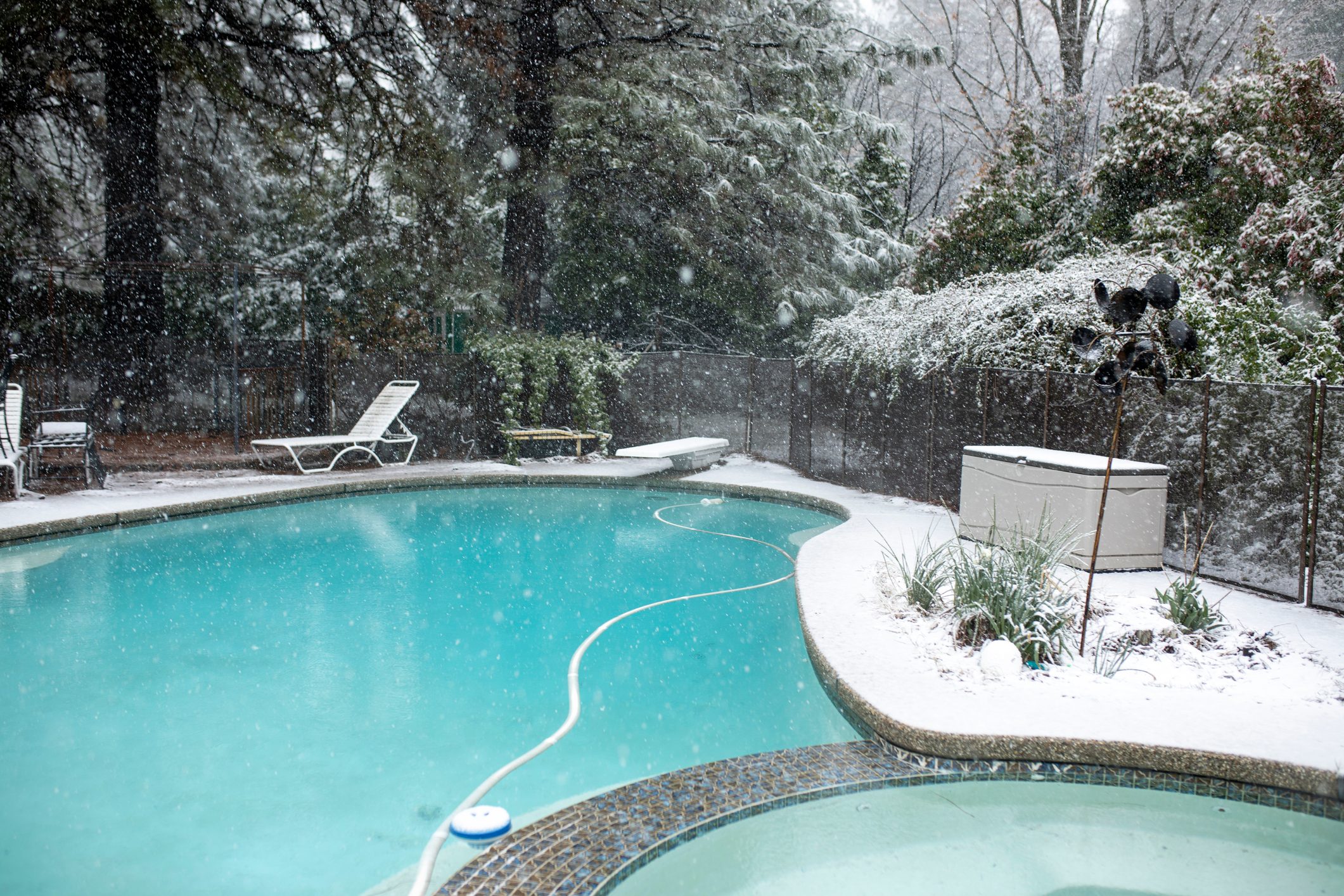 Backyard Winter Pool in Snow with Clear Blue Water and White Trees