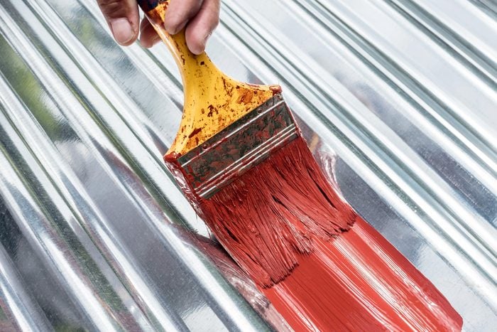 painting stainless steel with a red paint brush
