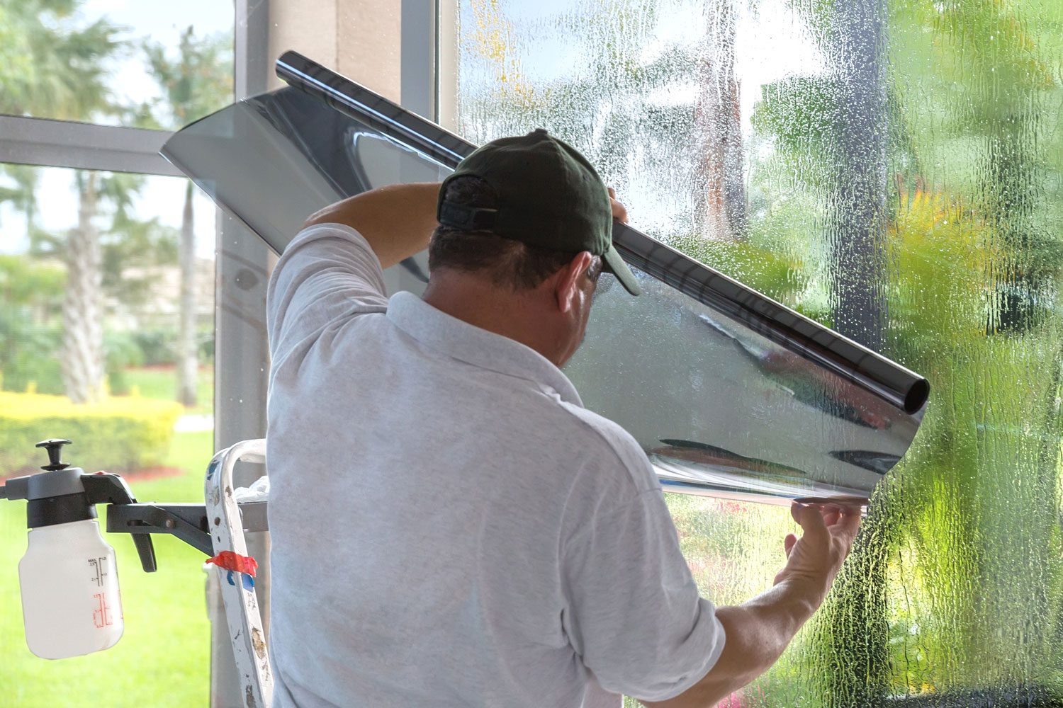 Employee works to install Window tinting in Florida where the sun makes the house very hot and fades furniture