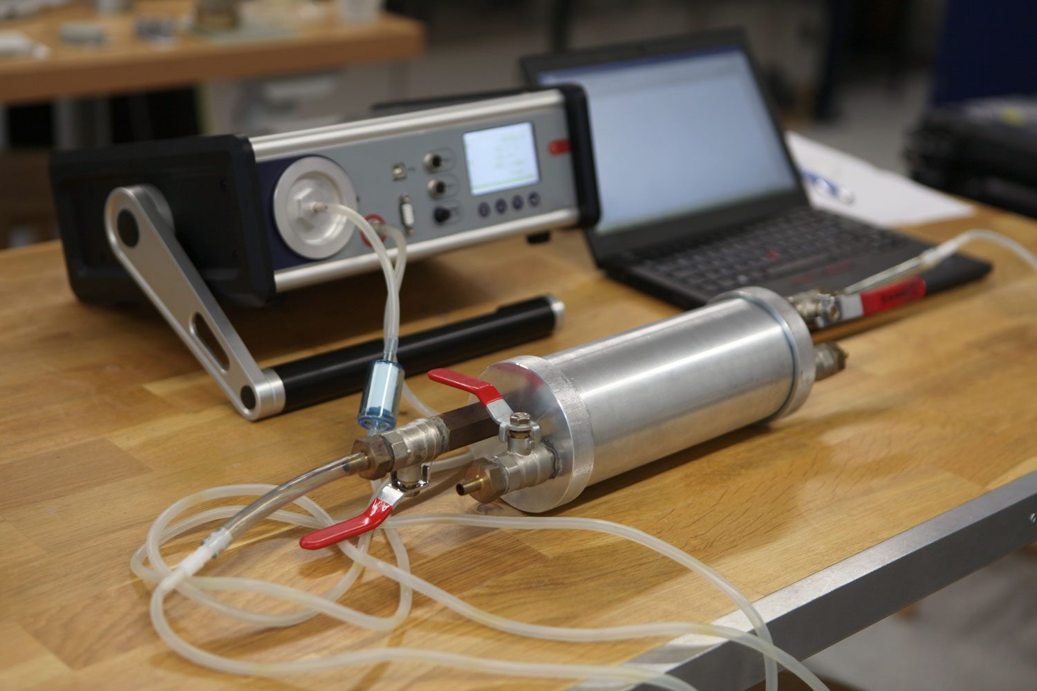 Dosimetrist holding a portable gamma radiation dosimeter set on a long tube with sample