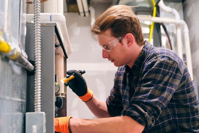 Home Repairman Working On A Furnace