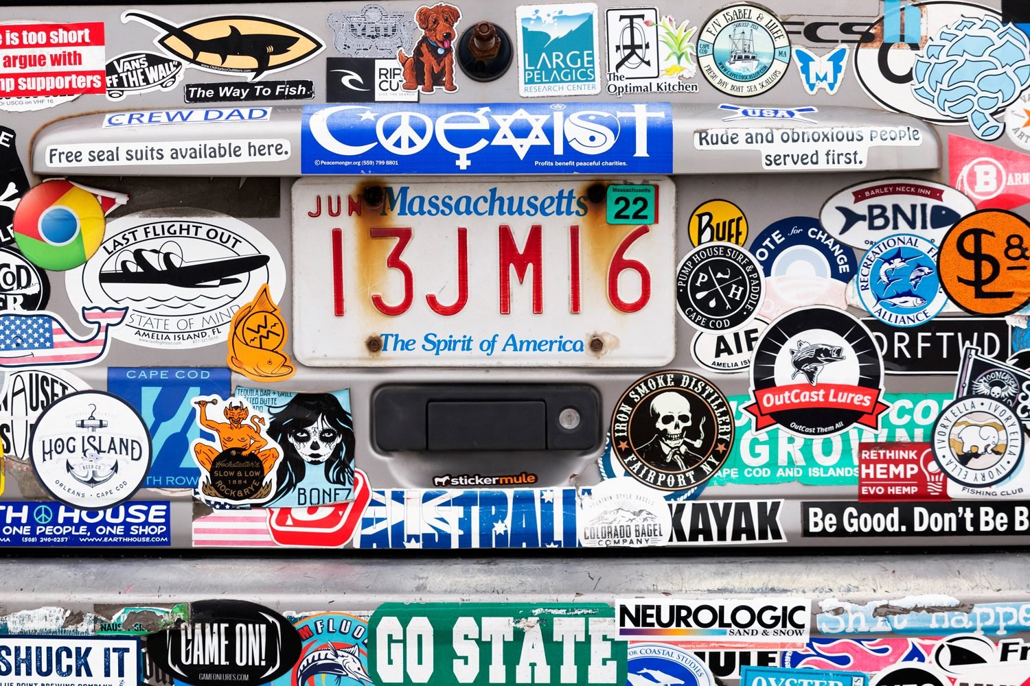 Massachusetts Car With Bumper Stickers On Display Covering the Back of the Unknown Car