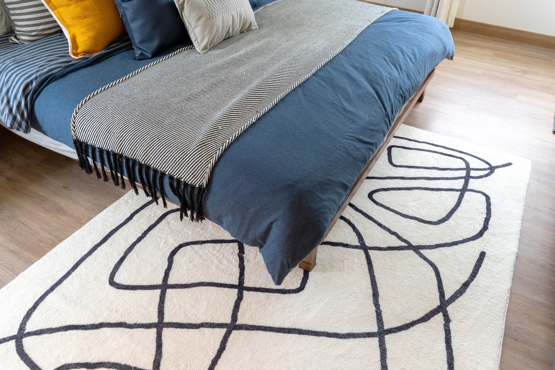 Modern graphic rug on the floor in a bedroom.