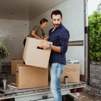 couple unloading boxes from a moving truck