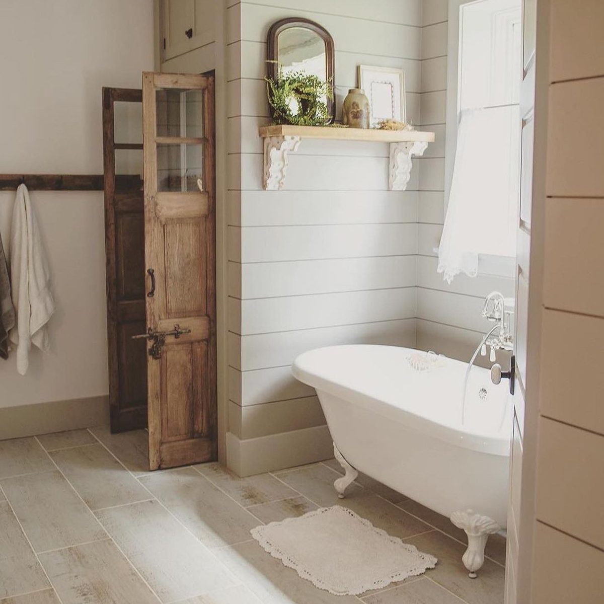 A vintage looking bathroom with bathtub and wooden door
