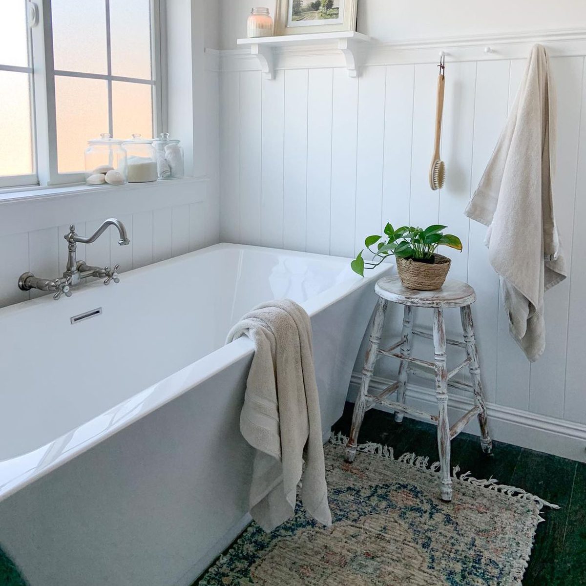 A bathtub inside a bathroom with white wall paneling
