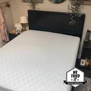 A bed with a mattress protector on it