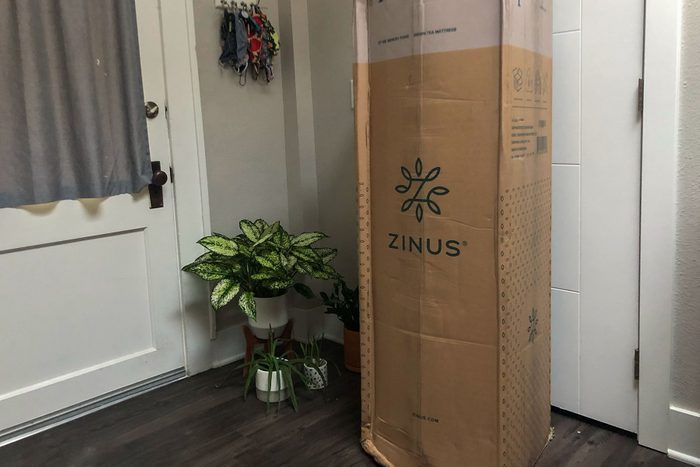 A box with a mattress sitting in front of a door.