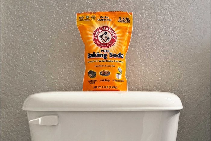 A bag of baking soda on top of a toilet tank