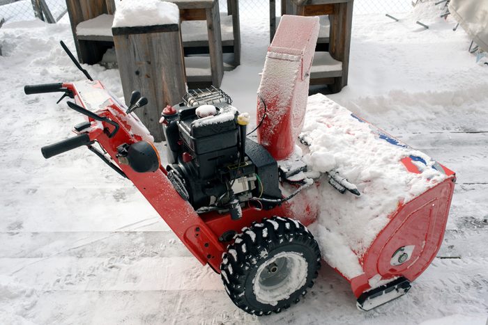 A manual snowplow or snow cleaning machine in the alps switzerland in a hotel garden