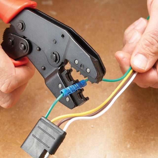 A person is using pliers to connect wires