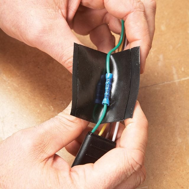 A person using tape to connect wires