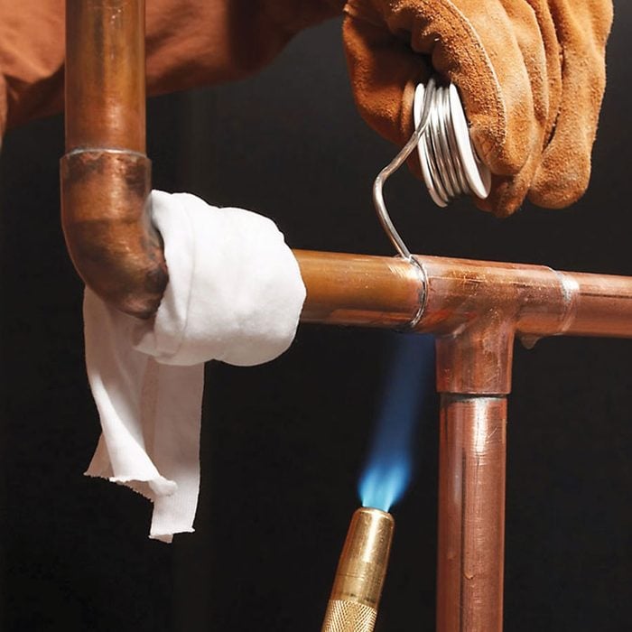 A wet white cloth wrapped around a copper pipe