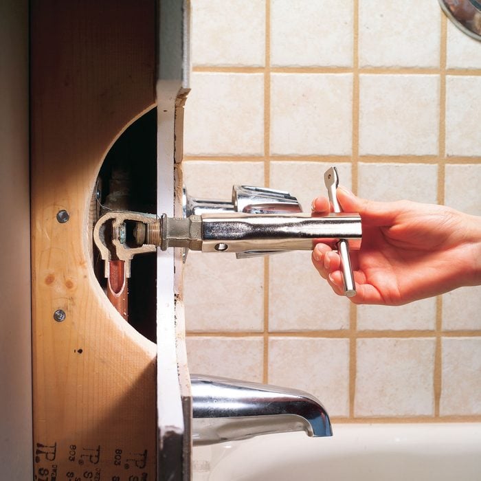 A Person Fixing Leaky Bathtub Faucet