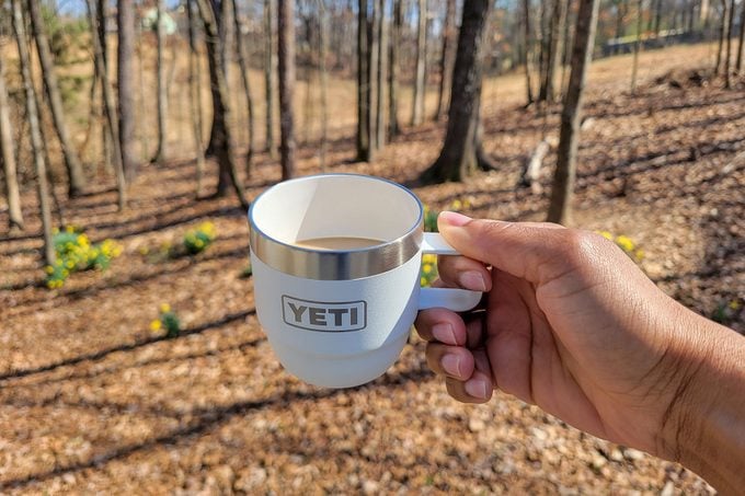 Holding Yetis New Stackable Cup in forest area