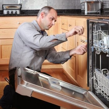 man fixing the seal on a dishwasher to prevent it from leaking