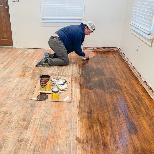 A Person Applying/Wiping Wood Stain on Hardwood Floor