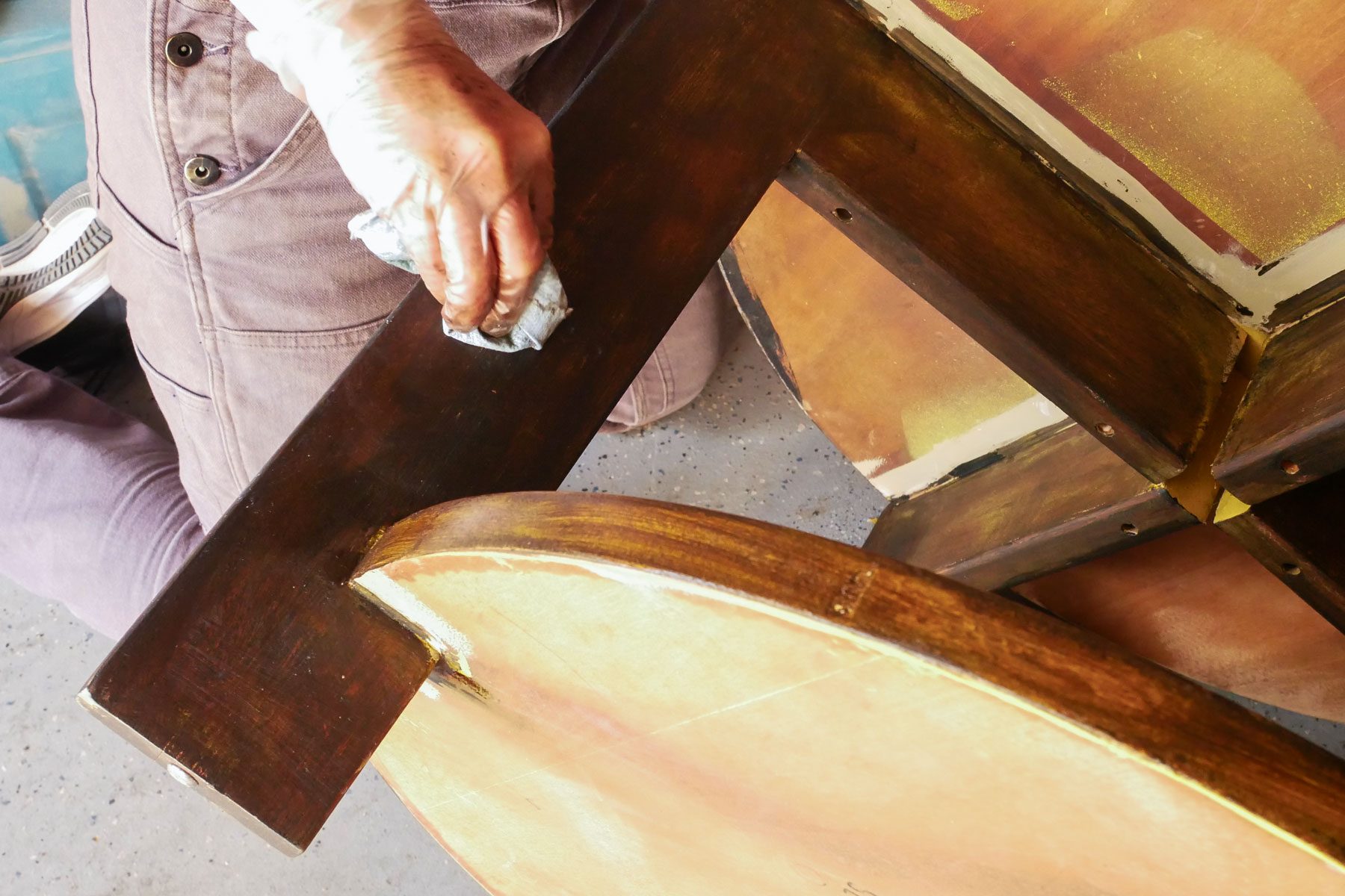 A person Apply wax topcoat on a wooden table